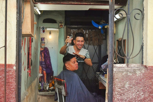 Man getting a haircut from a smiling barber